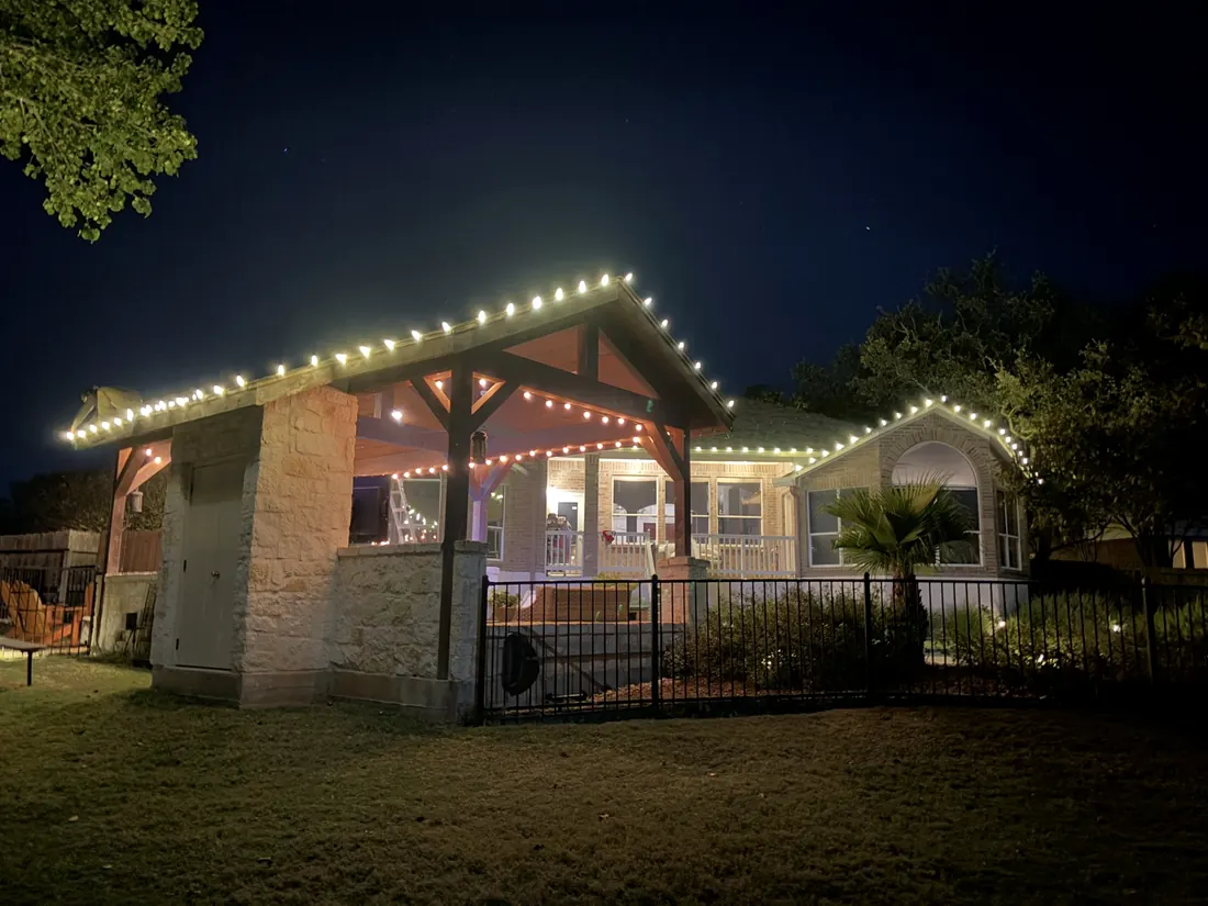 Porch and pergola outlined in warm white lights